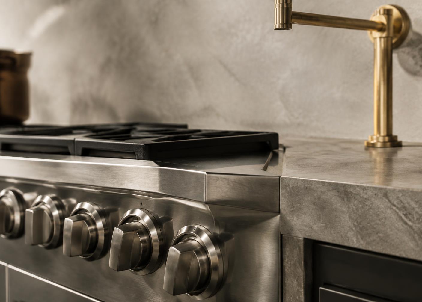 Detalhe de fogão profissional em inox e metal em latão
